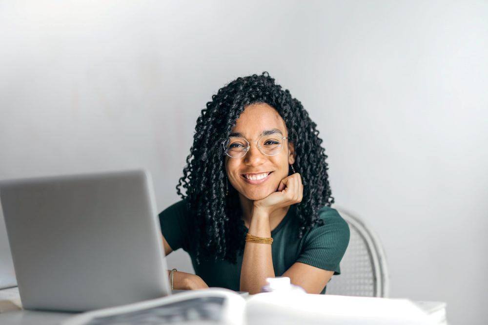 smiling woman at laptop thankful for free education for association professionals