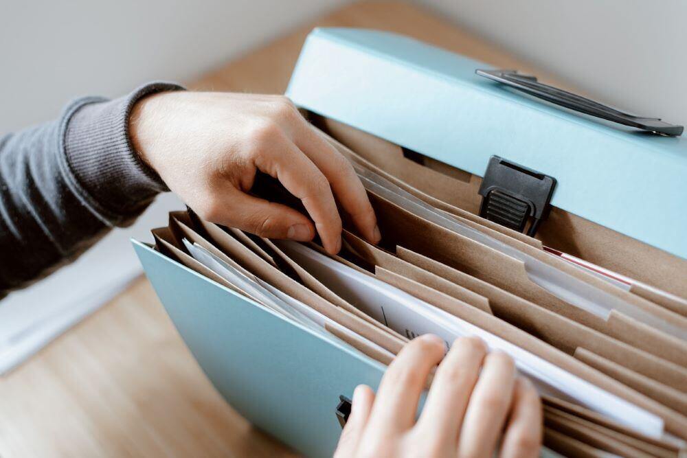 Hands searching a file folder - swipe file for association marketers