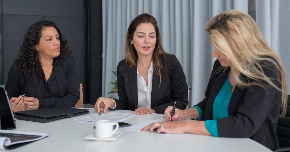 professional development as an employee retention strategy works for these three women sitting around a table at work